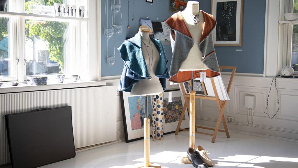 To utstillingsdukker med håndlagde tekstilplagg i butikken hos Østfold kunstsenter.