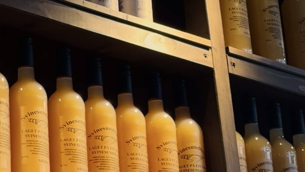 Flasker med eplemost fra Svinesundhagen i Halden på trehylle.