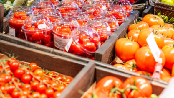 Nærbilde av ulike typer tomater i trekasser i gårdsbutikken.