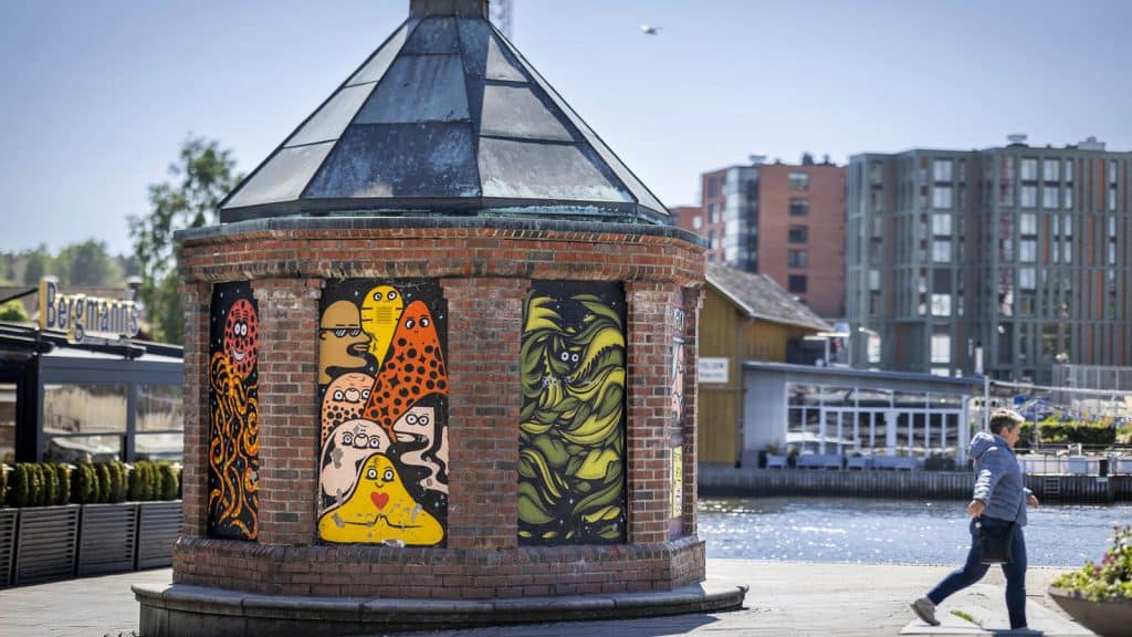 Fargerik gatekunst på murbygning ved elva i Fredrikstad.