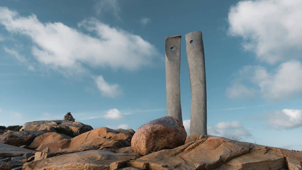 To høye granittsøyler står oppreist blant svaberg på Rødshue,