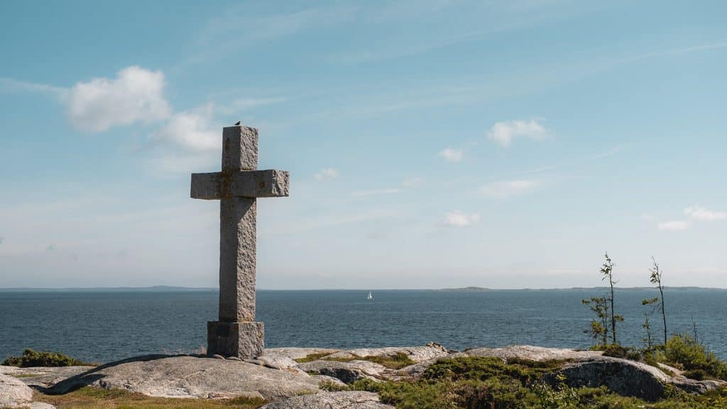 Steinkors står vendt mot havet på tuppen av Rødshue, med horisont i bakgrunnen.