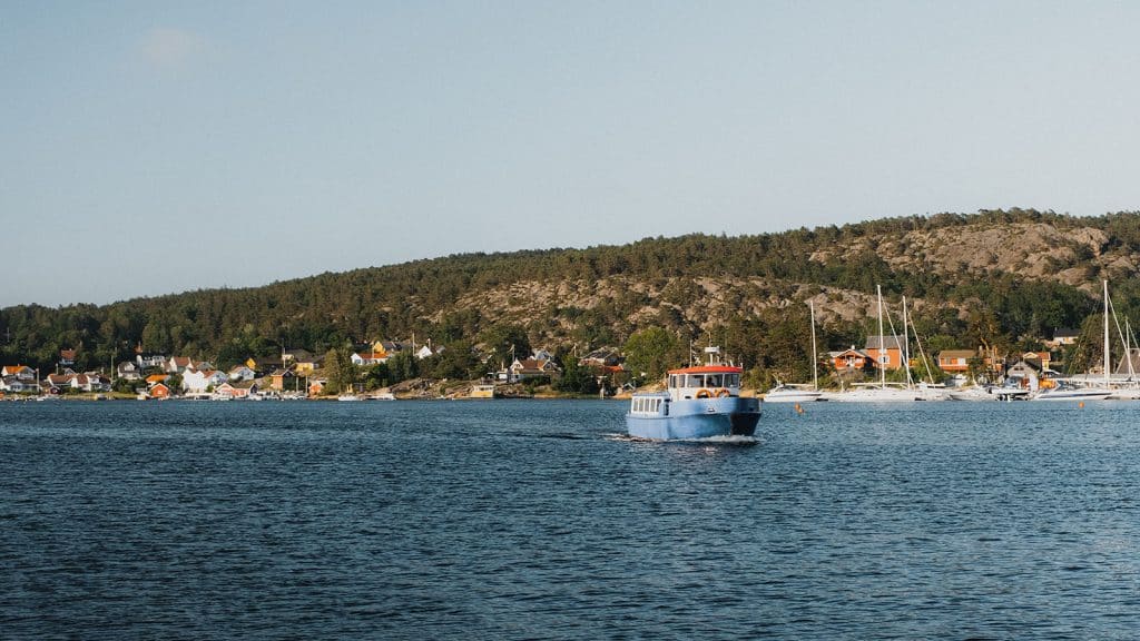 Hankøfergen på vei over sundet, med hus og båter i bakgrunnen.
