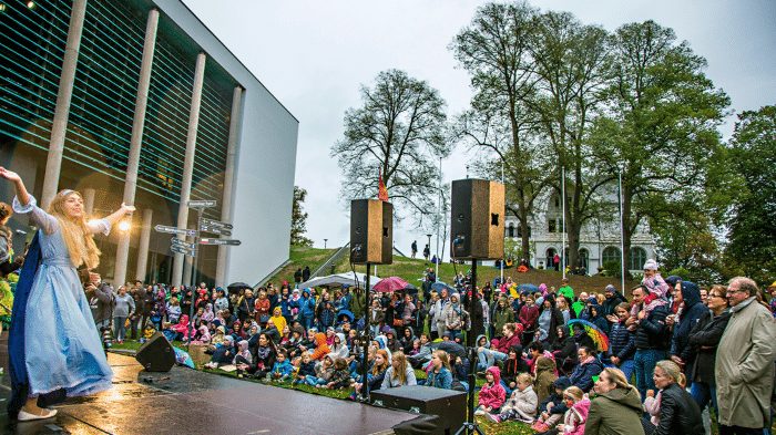 Familier og barn ser en utendørs forestilling foran Blå Grotte under Kulturnatt Fredrikstad.